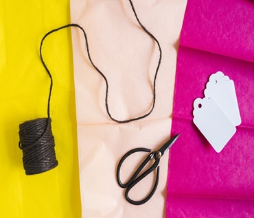 a tri color cloth with scissor and thread and paper